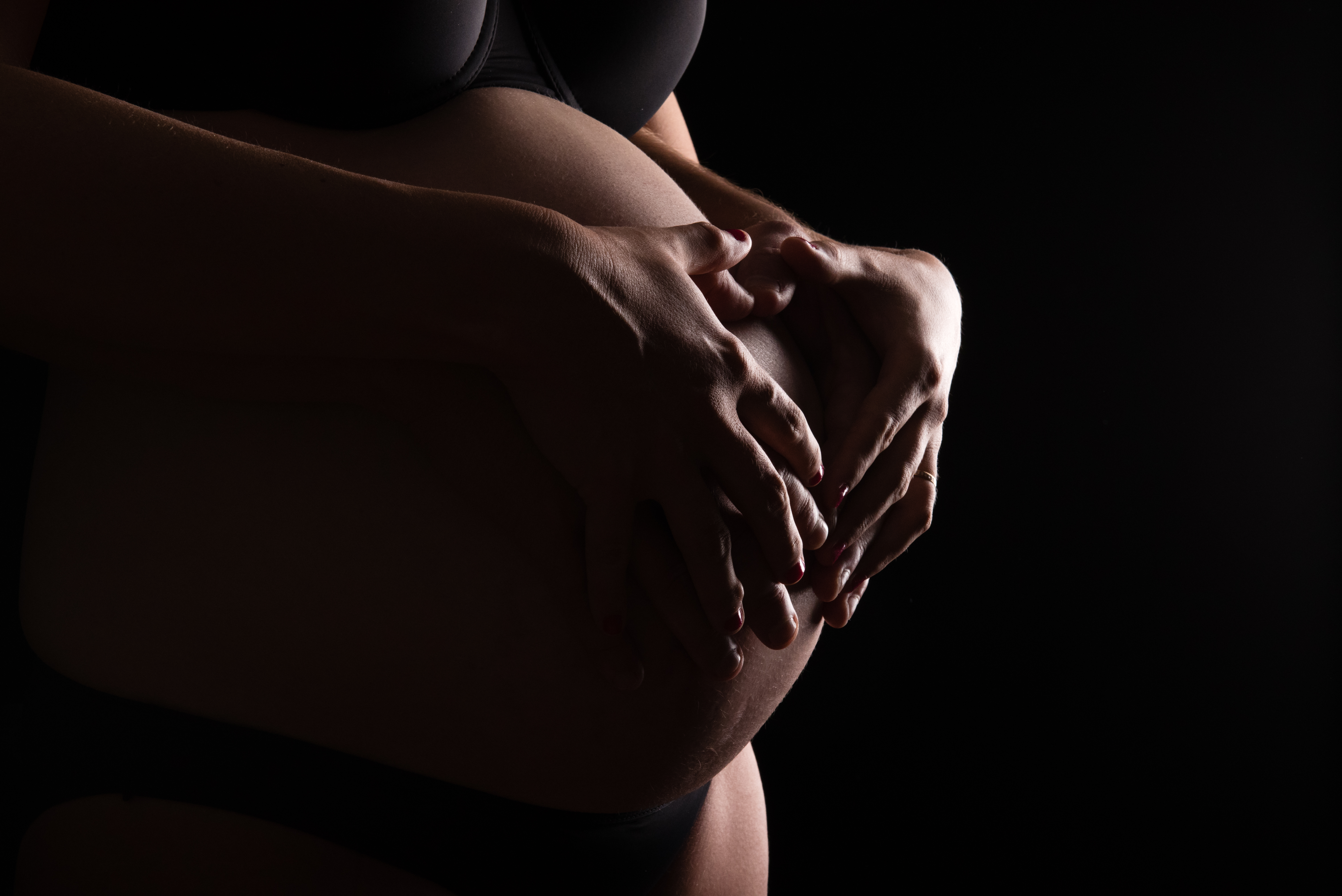 Mains sur le ventre, photo artistique de grossesse